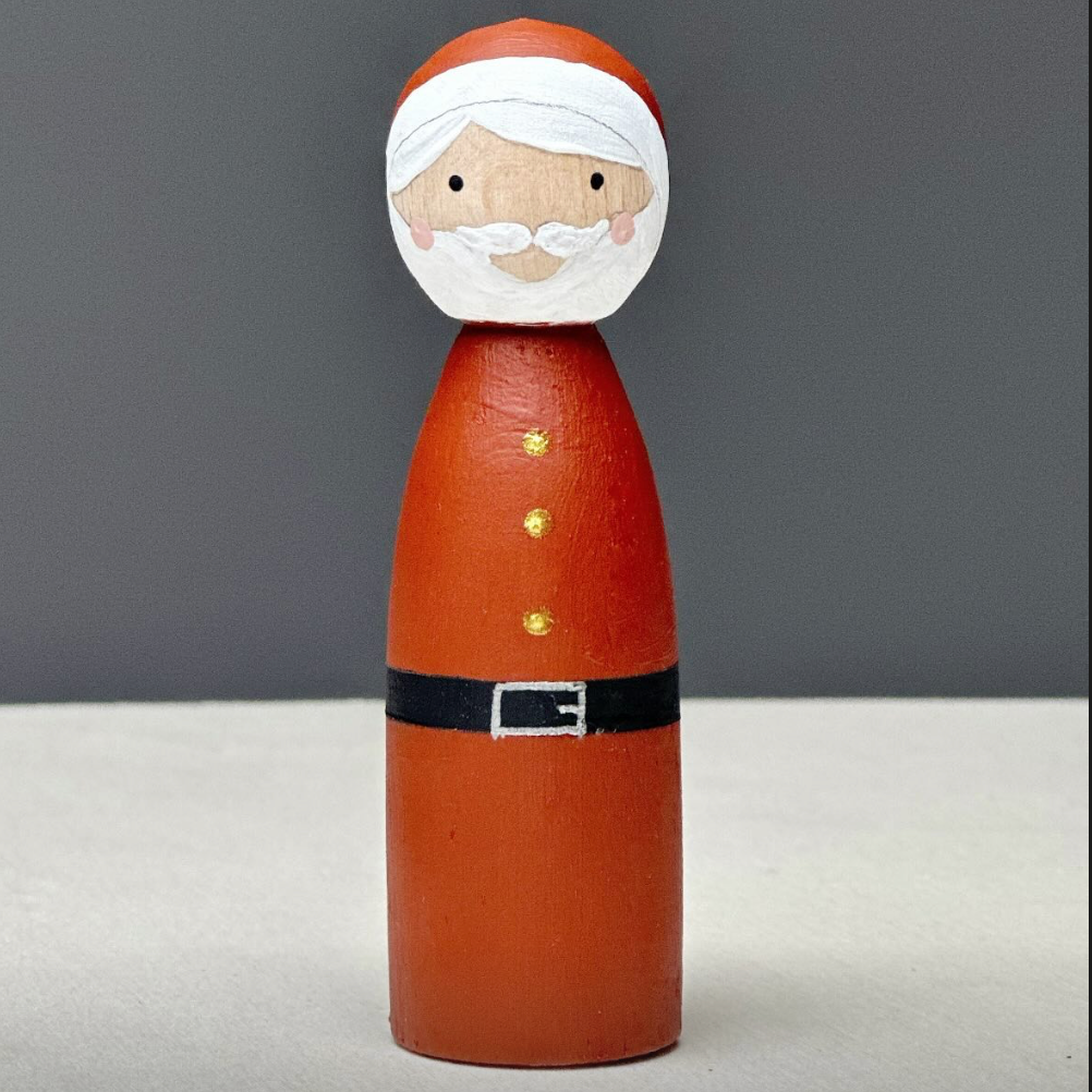 Wooden peg doll of Santa Claus on a gray background